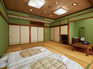 Postel nebo postele na pokoji v ubytování Sakura no Yakata Hotel