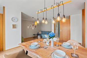 a dining room with a table with plates and wine glasses at Louise's City Apartment an der Uferpromenade in Friedrichshafen