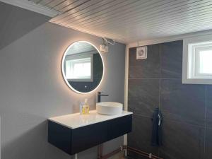 ein Bad mit einem Waschbecken und einem Spiegel in der Unterkunft Fin Sentralt Hybel i Drammen in Drammen