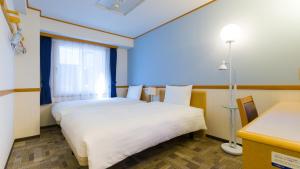 a hotel room with two beds and a window at Toyoko Inn Tokyo eki Shin ohashi Mae in Tokyo