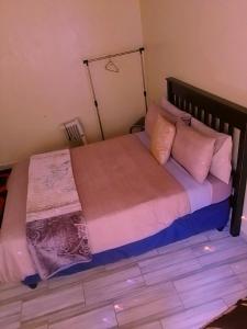 - une chambre avec un grand lit et des oreillers roses dans l'établissement MOFFAT GUEST HOUSE, à Randfontein