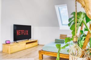 a bedroom with a bed and a tv on a dresser at Luxus Apartment! Küche, Balkon, Netflix, Parkplatz - 8 Personen in Ilmmünster