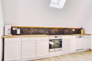 a kitchen with white cabinets and a counter top at Luxus Apartment! Küche, Balkon, Netflix, Parkplatz - 8 Personen in Ilmmünster