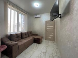 uma sala de estar com um sofá e uma televisão de ecrã plano em Arcadia Adelina em Odessa