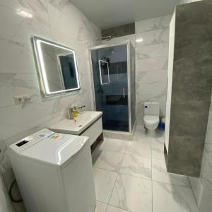 a bathroom with a toilet and a sink and a mirror at Arcadia Adelina in Odesa