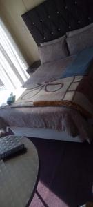 - un lit dans une chambre avec une table à côté dans l'établissement MOFFAT GUEST HOUSE, à Randfontein