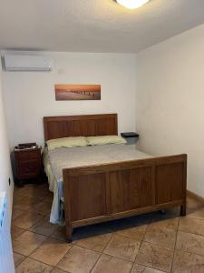 1 dormitorio con cama de madera en una habitación en Casa Esterina, en Garessio