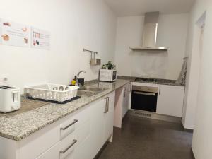 a kitchen with white cabinets and a sink at Private rooms in Born in Barcelona