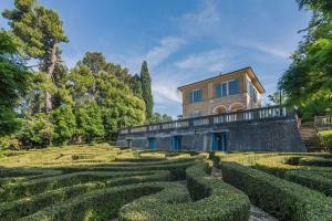 a house in the middle of a garden with hedges at Villa Liberty in Osimo