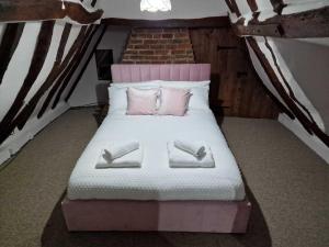 a bedroom with a bed with two pillows on it at Two Bedroom Grade ll Cottage At AZ Luxury Stays Honey Horsefield With WiFi And Free Parking in Hundon