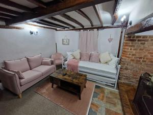 uma sala de estar com um sofá e uma mesa em Two Bedroom Grade ll Cottage At AZ Luxury Stays Honey Horsefield With WiFi And Free Parking em Hundon