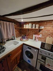 a kitchen with a sink and a washing machine at Two Bedroom Grade ll Cottage At AZ Luxury Stays Honey Horsefield With WiFi And Free Parking in Hundon