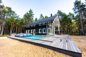 a black house with a pool on a wooden deck at Dirhami Pool Villa in Dirhami