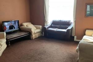 a living room with a couch and a tv and chairs at Bloomsbury 2 room flat in London