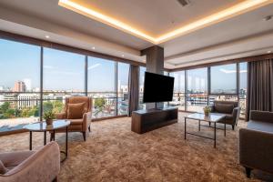 a living room with a flat screen tv and large windows at Park Dedeman Kızılay Ankara in Ankara