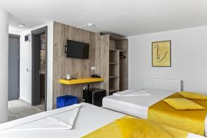ein Hotelzimmer mit zwei Betten und einem Fernseher in der Unterkunft Hotel Aqua Park in Eforie Nord