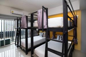 2 Etagenbetten in einem Zimmer mit Balkon in der Unterkunft Bell Lifestyle Hostel Phuket in Nai Yang Beach