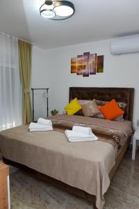 una camera da letto con un grande letto con asciugamani di Apartmani Simić a Kuršumlija