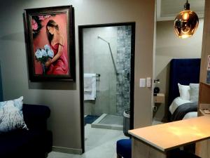 a bathroom with a painting of a woman with flowers at Bella Ragazza Accommodation in Mooinooi