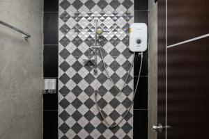 a shower in a bathroom with a checkered wall at Bell Lifestyle Hostel Phuket in Nai Yang Beach
