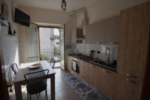 a kitchen with a table and chairs and a kitchen with a balcony at Casa San Martino in Castiglione di Sicilia