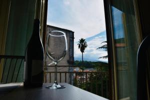 a wine glass sitting on a table next to a window at Casa San Martino in Castiglione di Sicilia