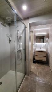 een badkamer met een glazen douche en een wastafel bij Hotel Cardiff in Oostende
