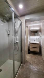 a bathroom with a glass shower and a sink at Hotel Cardiff in Ostend +33 photos