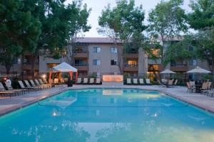 a pool at a hotel with tables and chairs at Mountain View 1BR w WD Pool Gym nr groceries SFO-1067 in Mountain View