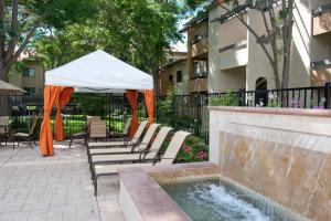 a patio with chairs and an umbrella and a fountain at Mountain View 1BR w WD Pool Gym nr groceries SFO-1067 in Mountain View