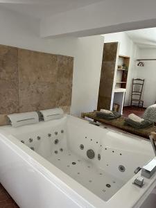 La salle de bains est pourvue d'une grande baignoire blanche. dans l'établissement La Recampado, à Bormes-les-Mimosas