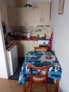 una cocina con mesa con 2 sillas y mesa y una cocina con en Apartmán Zlín, en Zlín