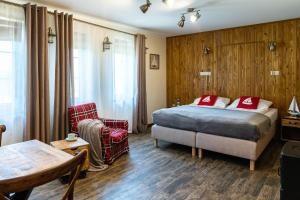Habitación de hotel con cama, silla y mesa en Ostoja Dwa Jeziora en Węgorzewo