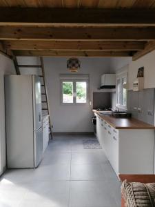 a kitchen with a white refrigerator and a window at Ti Kaz Dakoté le bungalove in Sainte-Clotilde