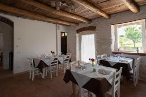 un comedor con mesas blancas y sillas blancas en Arcadia Agriturismo, en San Nicola Manfredi