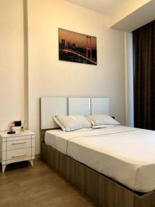 um quarto com uma cama grande, uma mesa de cabeceira e uma fotografia em Luxury flat with Sea & City view - Gym & Parking ( 93 ) - 9255745 em Beylikdüzü