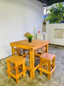 uma mesa e banco de madeira com uma planta em vasos em Cik Misi Homestay (2) em Sik