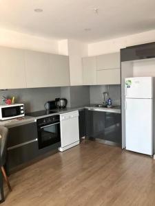 uma cozinha com electrodomésticos brancos e um frigorífico preto e branco em Luxury flat with Sea & City view - Gym & Parking ( 93 ) - 9255745 em Beylikdüzü