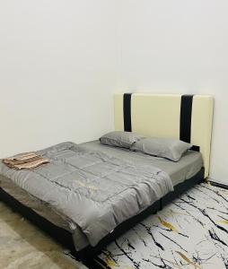 uma cama num quarto com uma parede branca em Cik Misi Homestay (2) em Sik