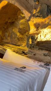 un primer plano de una cama en una cueva en Hanging Terraces المدرجات المعلقة en Al ‘Aqar