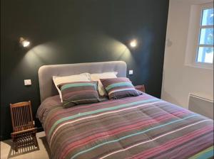 um quarto com uma cama grande e um edredão listrado em Jolie maison Pays d'Aix em Rognes