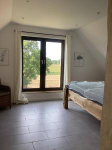 a bedroom with a bed and a large window at Storchennest am Dümmer in Lembruch