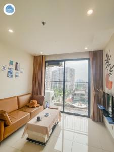 sala de estar con sofá y ventana grande en It Dust Homestay 1 - The Ocean Apartment, en Hanói