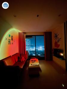 ein Wohnzimmer mit einem roten Sofa und einem großen Fenster in der Unterkunft It Dust Homestay 1 - The Ocean Apartment in Hanoi