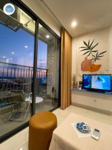 uma sala de estar com uma grande janela e uma televisão em It Dust Homestay 1 - The Ocean Apartment em Hanói