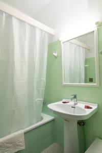 a bathroom with a sink and a mirror and a tub at Hotel Galera in San Antonio