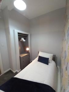 a small bedroom with a bed and a mirror at The Nifty Nook in Campbeltown