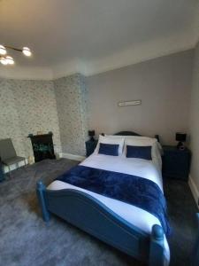 a bedroom with a large bed with two blue pillows at The Nifty Nook in Campbeltown