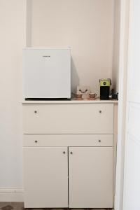 a white dresser with a microwave on top of it at Civico 10 Deluxe Room in Licata