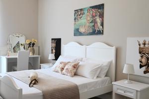 a white bedroom with a large white bed with pillows at Civico 10 Deluxe Room in Licata